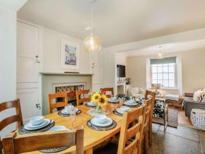 a kitchen and living room with a wooden table and chairs at 4 Bed in Bideford oc-88876 in Appledore