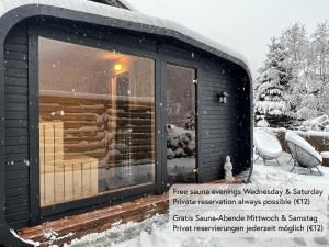 a cabin in the snow with a large window at Alpine Apartments St-Sigmund in Sankt Sigmund im Sellrain