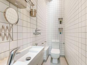 a white tiled bathroom with a toilet and a sink at 4 Bed in Bideford oc-88876 in Appledore +17 photos