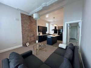 a living room with a couch and a brick wall at Spacious Victorian Apt Sleeps 5 Parking available in Nottingham