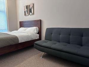 a bed and a couch in a bedroom at Spacious Victorian Apt Sleeps 5 Parking available in Nottingham