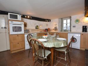 a kitchen with a table with chairs and a microwave at 3 Bed in Arthog oc-66579 in Arthog