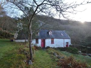 a white house with a red door in a field at 3 Bed in Arthog oc-66579 in Arthog