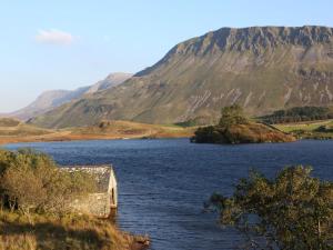 an island in a body of water with mountains in the background at 3 Bed in Arthog oc-66579 in Arthog +14 photos