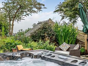 a garden with a hot tub in a yard at 1 Bed in Kilgetty oc-59667 in Yerbeston