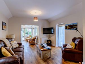 a living room with leather couches and a table at 1 Bed in Kilgetty oc-59667 in Yerbeston