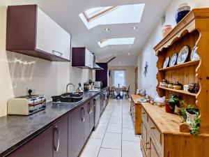 a large kitchen with wooden cabinets and a counter top at 1 Bed in Kilgetty oc-59667 in Yerbeston