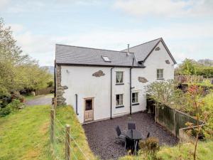 a white house with a table in front of it at 2 Bed in Colwyn Bay oc-74147 in Eglwys-Fâch