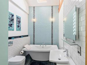 a bathroom with a tub and a toilet and a sink at 3 Bed in Colwyn Bay oc-74146 in Eglwys-Fâch +22 photos