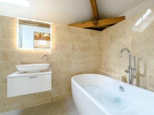 a bathroom with a tub and a sink at 1 Bed in South Molton oc-59339 in Knowstone +20 photos