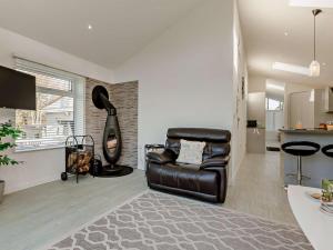 a living room with a leather chair and a kitchen at 2 Bed in Brixham oc-90912 in Brixham