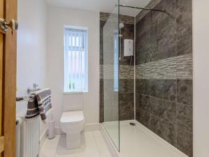 a bathroom with a toilet and a glass shower at 4 Bed in Llandudno oc-75466 in Llandudno +23 photos