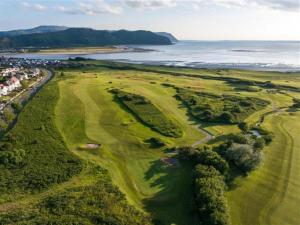 an aerial view of a golf course next to the ocean at 4 Bed in Llandudno oc-75466 in Llandudno