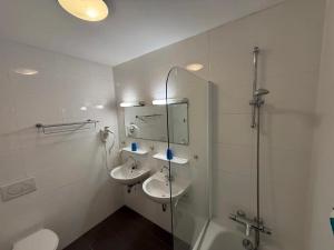 ein Badezimmer mit zwei Waschbecken und einer Glasdusche in der Unterkunft Hotel Rasch in Bergen aan Zee + 134 Fotos