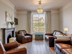 a living room with leather furniture and a large window at 6 Bed in Dolgellau oc-91711 in Dolgellau