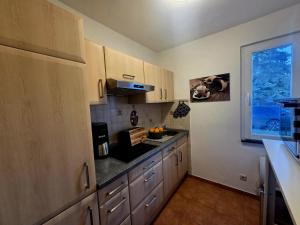 a kitchen with wooden cabinets and a counter top at Ferienhaus am Tänntalbach in Öhrenfeld