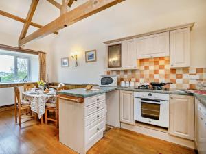 a kitchen with white cabinets and a dining room with a table at 2 Bed in Bridport oc-94222 in Bridport