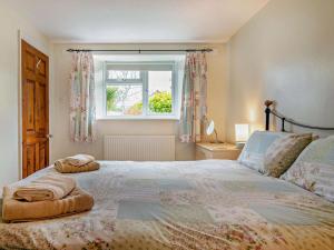 a bedroom with a large bed with a window at 2 Bed in Bridport oc-94222 in Bridport
