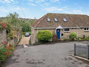a brick house with a blue door and a driveway at 2 Bed in Bridport oc-94222 in Bridport