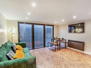 a living room with a green couch and a table at 2 Bed in Rhyl oc-94036 in Kinmel Bay