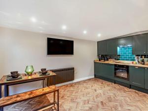 a kitchen with green cabinets and a flat screen tv at 2 Bed in Rhyl oc-94036 in Kinmel Bay