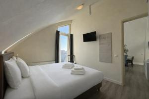 ein Schlafzimmer mit einem weißen Bett und einem großen Fenster in der Unterkunft Hotel Rasch in Bergen aan Zee