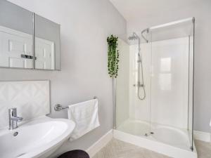 a white bathroom with a sink and a shower at 5 Bed in Ilfracombe oc-89563 in Ilfracombe +19 photos