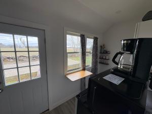 a kitchen with a microwave and a refrigerator and windows at Large King Suite Completely Private Space Stay close enough to Newport without the Noise in Portsmouth