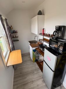 a small kitchen with a white refrigerator and a sink at Large King Suite Completely Private Space Stay close enough to Newport without the Noise in Portsmouth +2 photos