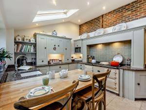 a large kitchen with a wooden table and chairs at 3 Bed in Heathfield oc-93718 in Dallington +19 photos