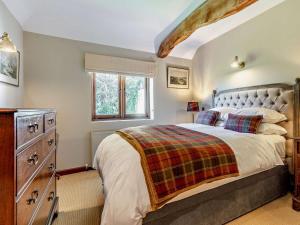 a bedroom with a large bed and a dresser at 3 Bed in Heathfield oc-93718 in Dallington