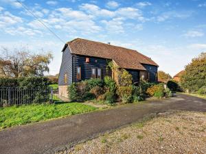 an old black house with a rusty roof on a road at 3 Bed in Heathfield oc-93718 in Dallington