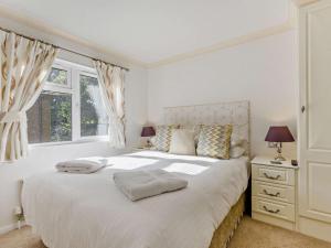a white bedroom with a large bed and a window at 3 Bed in Okehampton oc-95636 in Okehampton