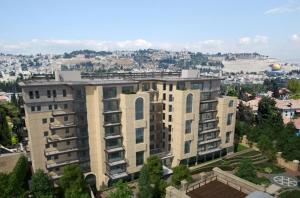 a large apartment building in front of a city at Naama New Boutique Apartment in Jerusalem