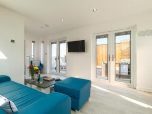 a living room with a blue couch and a tv at 1 Bed in Ilfracombe oc-52915 in Ilfracombe
