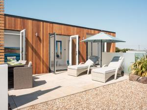 a patio with two chairs and an umbrella at 1 Bed in Ilfracombe oc-52915 in Ilfracombe