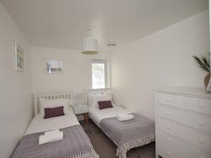 a bedroom with two beds and a dresser at 2 Bed in Y Felinheli oc-86260 in Y Felinheli