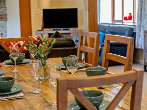 a dining room table with glasses and flowers on it at 4 Bed in Ilfracombe oc-43640 in Berrynarbor