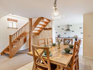 a kitchen and dining room with a wooden table and stairs at 4 Bed in Ilfracombe oc-43640 in Berrynarbor