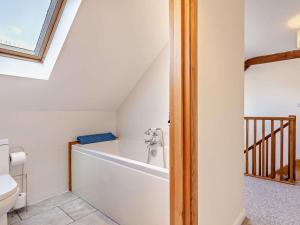 a bathroom with a tub and a toilet at 4 Bed in Ilfracombe oc-43640 in Berrynarbor +20 photos