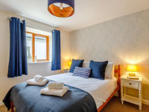 a bedroom with two beds with blue curtains at 2 Bed in Ilfracombe oc-rugga in Berrynarbor +11 photos