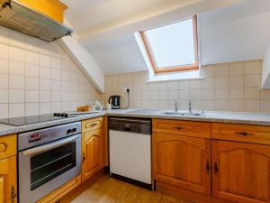 a kitchen with wooden cabinets and a sink and a window at 2 Bed in Ilfracombe oc-rugga in Berrynarbor