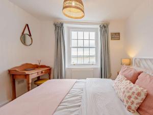a bedroom with a bed and a desk and a window at 2 Bed in Bideford oc-52863 in Appledore