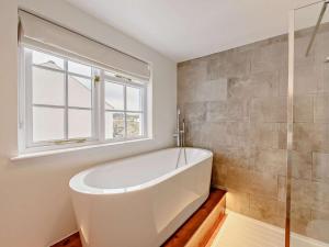 a white bath tub in a bathroom with a window at 2 Bed in Bideford oc-52863 in Appledore +15 photos