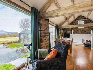 a living room with a stone wall and a large window at 2 Bed in Arthog oc-66611 in Arthog