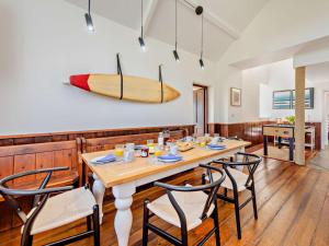 a dining room with a table and a surfboard on the wall at 3 Bed in Barnstaple oc-53109 in Braunton