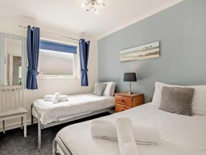 a bedroom with two beds and a window with blue curtains at 2 Bed in Brixham oc-bx079 in Brixham +16 photos