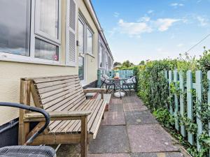 a patio with a wooden bench and a table at 2 Bed in Brixham oc-bx079 in Brixham