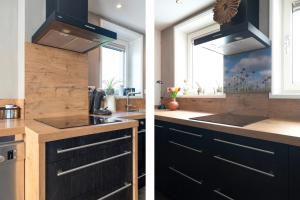 a kitchen with black cabinets and a sink at Guesthouse Eindeloos in 't Zand - North Holland in 't Zand