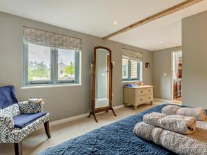 a bedroom with a blue bed and a chair and windows at 5 Bed in Dulverton oc-41133 in Brushford